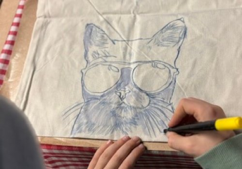 deelnemer tekent op tote bag workshop Hello Mojo Kortrijk creatieve workshop tas ontwerpen